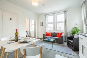 Relax in a spacious living area with a dining table, comfortable seating, and a cozy coffee table.