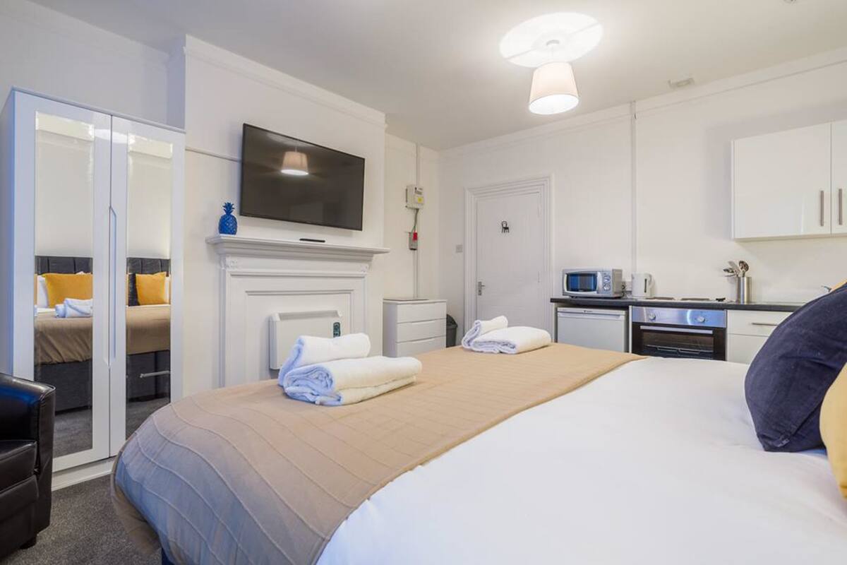 Een hotelkamer met een bed, een televisie, een magnetron en een kleine kitchenette.