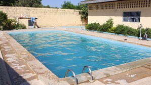 A swimming pool with a tiled edge and metal handrails. - Hotel Le Sahel (Maroua)