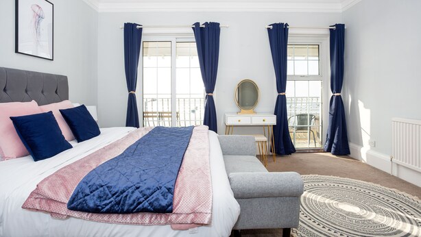 A bedroom with a bed, a desk, and a chair. - Compass Point by Sorted Stay  (Southend-on-Sea)