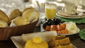 A table with various food items including bread, fruits, and a glass of juice.