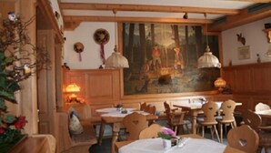 Un'accogliente sala da pranzo con mobili in legno, un quadro di grandi dimensioni appeso al muro e un'atmosfera calda.