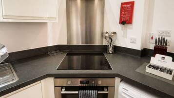 A modern kitchen with a stainless steel range hood, a built-in oven, and a dishwasher.