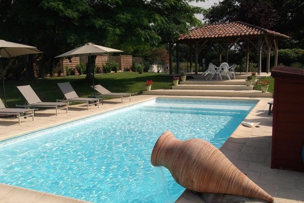 Een seizoensgebonden buitenzwembad en parasols bij het zwembad