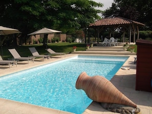 Piscine extérieure en saison, parasols, chaises longues
