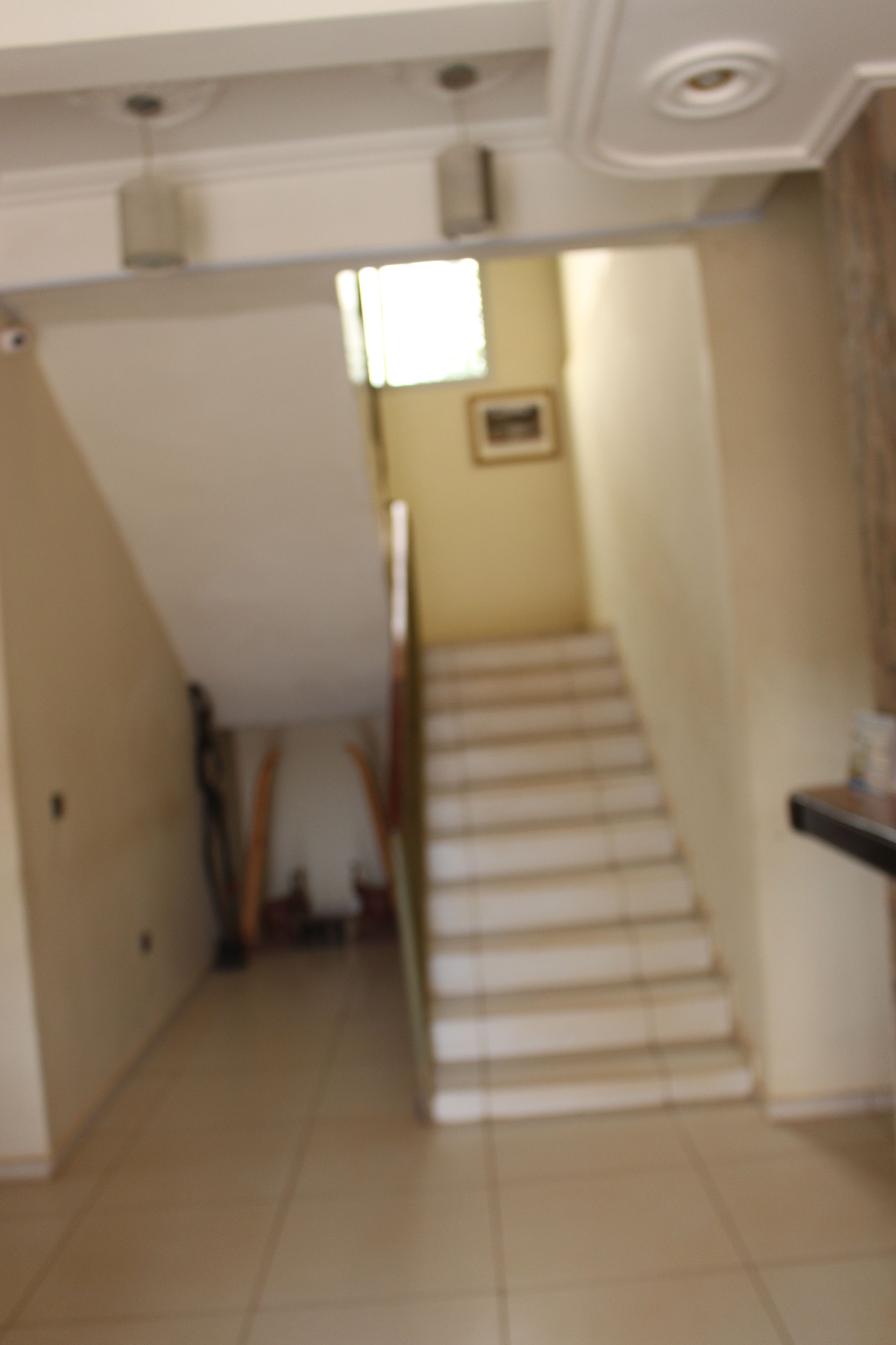 Una escalera que lleva a una plataforma con un accesorio de iluminación en el techo.