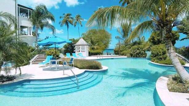 A swimming pool with lounge chairs and palm trees. - Schooner Bay 201 - Condo Flamboyant (Speightstown)