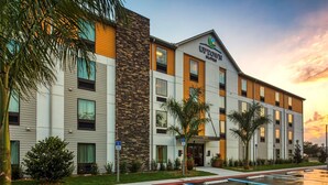 A modern hotel with a stone facade, multiple windows, and a sign indicating it is a senior suite. - Uptown Suites Extended Stay Tampa FL – Riverview (Riverview)