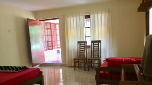 A room with a bed, a table, two chairs, and a window with curtains. - Benjohostel (Seeduwa - Katunayake)