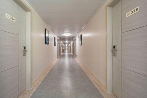 Un largo pasillo de hotel estrecho con puertas numeradas 334 y 339, que conduce a las habitaciones.
