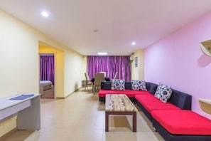 A room with a red sofa, a wooden table, a desk, and a purple curtain. - Heyi Express Hotel (Zhuhai Weichuangli Industrial Park) (ZHUHAI)