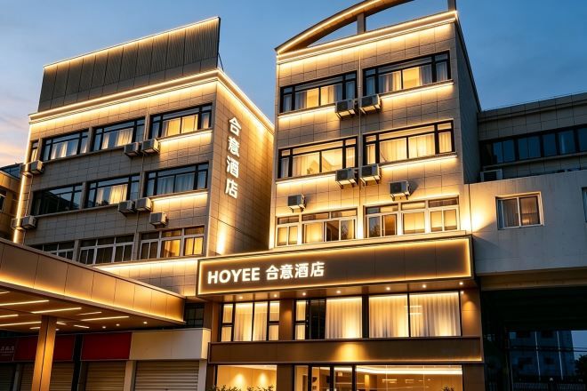 A modern hotel building with multiple floors, large windows, and a prominent sign.