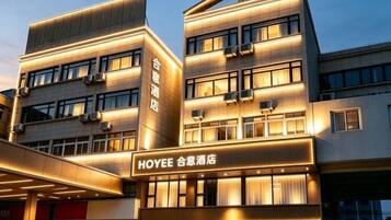 A modern hotel building with multiple floors, large windows, and a prominent sign.