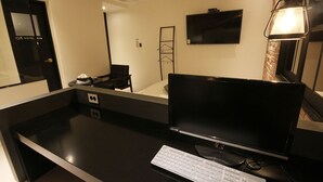 Une chambre d’hôtel équipée d  ’un bureau, d’un ordinateur et d’un clavier.