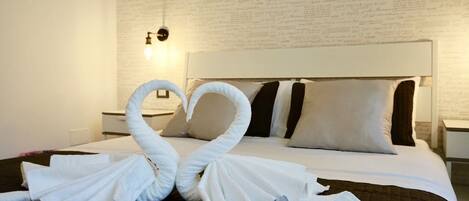 Ein Hotelzimmer mit einem Bett, Kissen, einem Nachttisch und einer Wand mit Schrift.