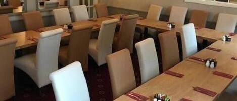 A conference room with a long table, multiple chairs, and a chandelier.
