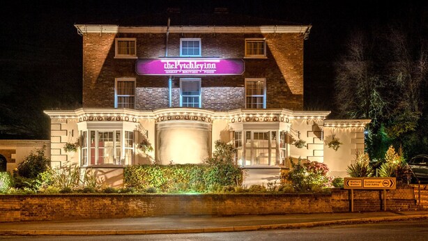A traditional building with a prominent sign reading "The Pyxhill Inn" and a well-lit entrance.