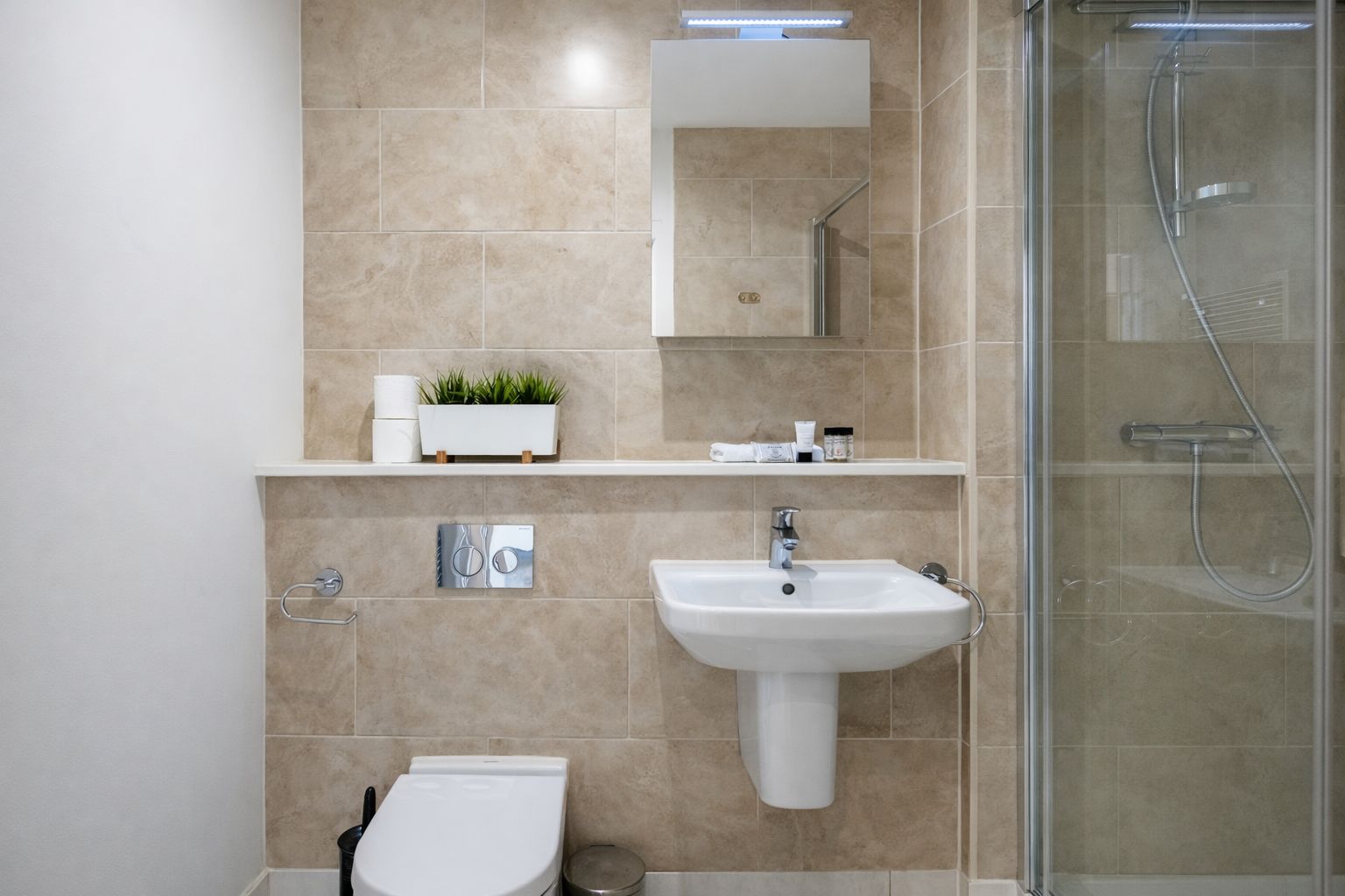 A modern bathroom with a toilet, sink, and shower.