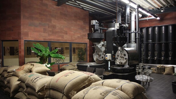 Une pièce de style industriel, avec des piles de sacs, du matériel industriel et un mur de briques.