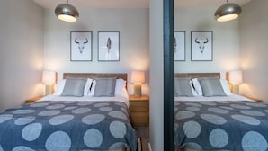A mirrored room with a bed, two wall-mounted lamps, and two framed pictures of animal skulls. - Exhale (Southend-on-Sea)