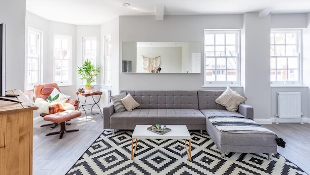 A modern living room with a grey sofa, a coffee table, and a patterned rug. - Exhale (Southend-on-Sea)