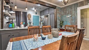 Un coin repas avec une table en bois, des chaises et un chemin de table bleu à motifs.