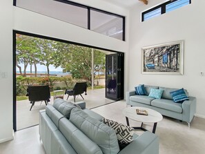 A modern living room with a grey sofa, a coffee table, and a painting on the wall.