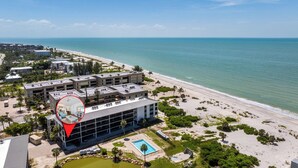 Vue aérienne d’un hôtel comprenant plusieurs bâtiments, une piscine et une plage.
