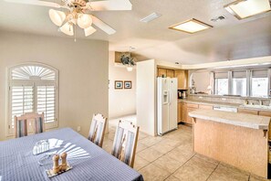 Enjoy cooking in this well-equipped kitchen with a central island, refrigerator, and dining area.