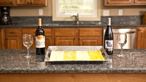 Un comptoir de cuisine avec deux bouteilles de vin et deux verres à vin vides.