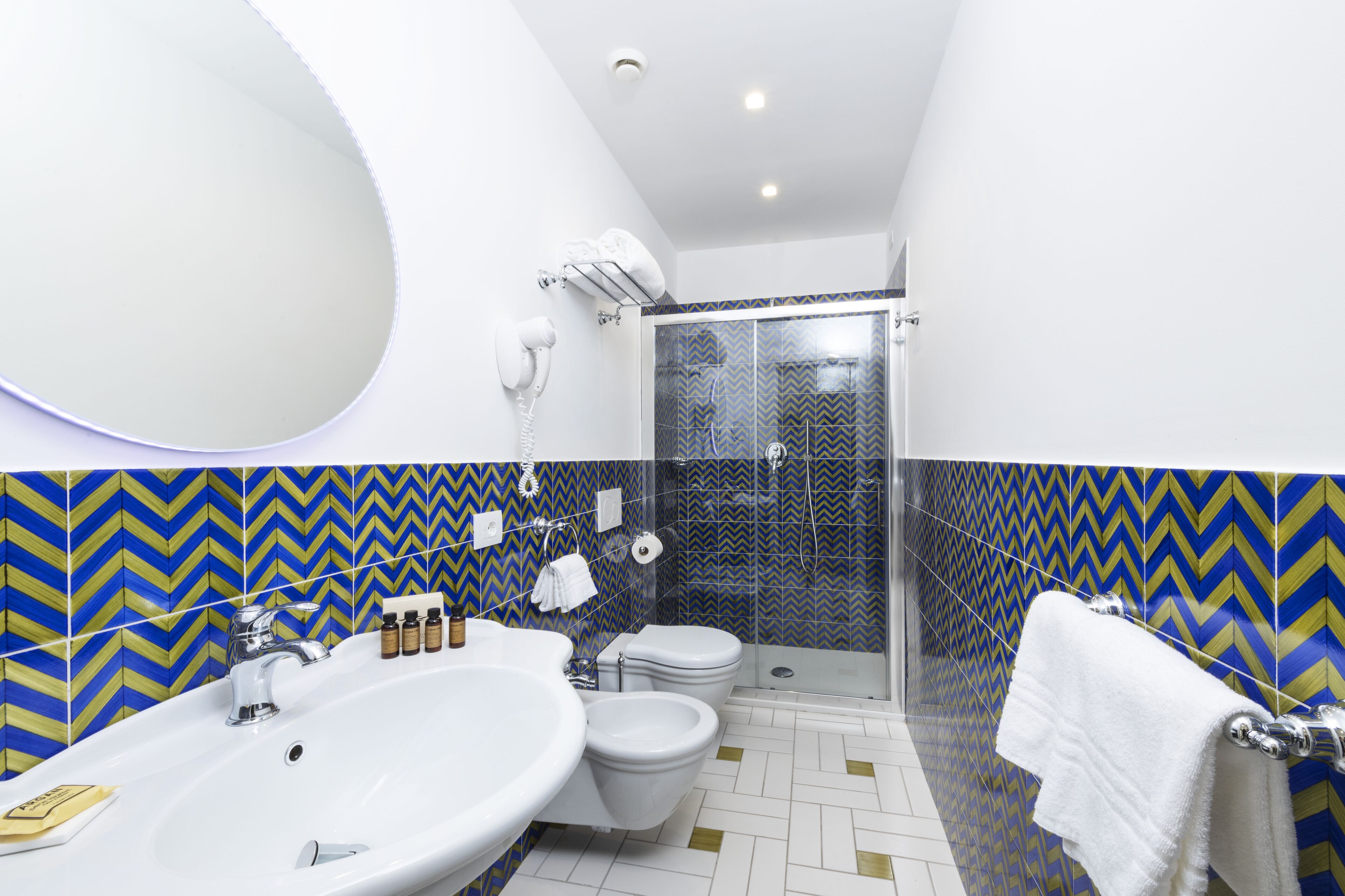 A bathroom with a large sink, toilet, and shower.