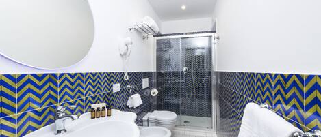 A bathroom with a large sink, toilet, and shower.