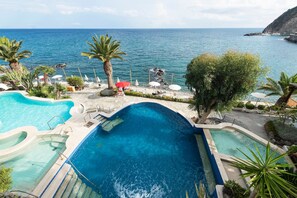 A pool area with multiple swimming sections and a view of the sea. - Apollon Club (Serrara Fontana)