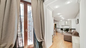Een modern appartement met een zithoek, kitchenette en balkon met uitzicht.