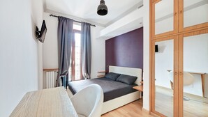 Een moderne slaapkamer met een bed, een bureau en een stoel.