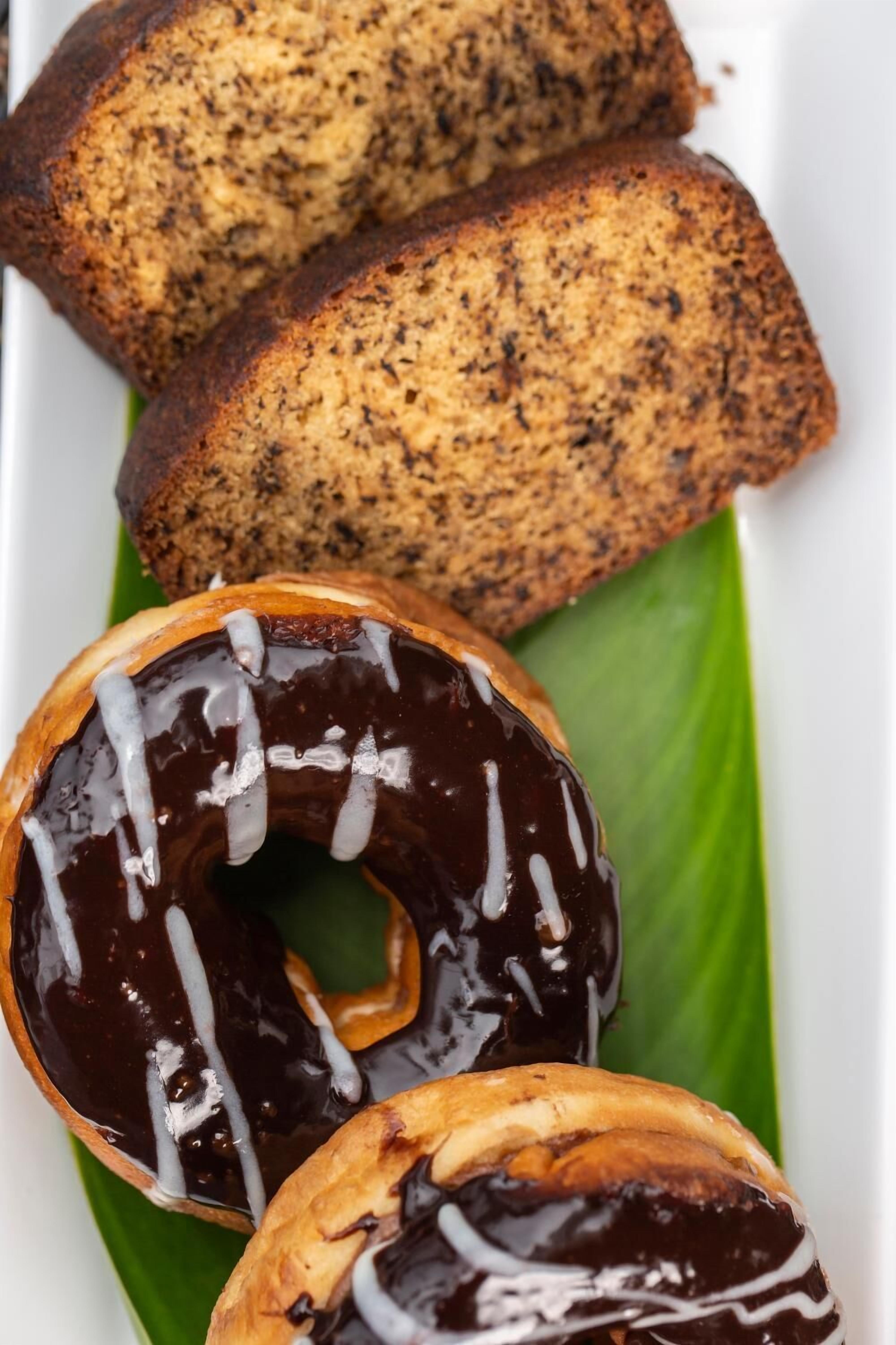 Un plato con dos rebanadas de pan y una rosquilla con glaseado de chocolate.