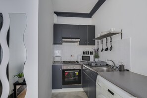 Efficient kitchen with sleek cabinetry, stainless steel sink, and compact appliances.