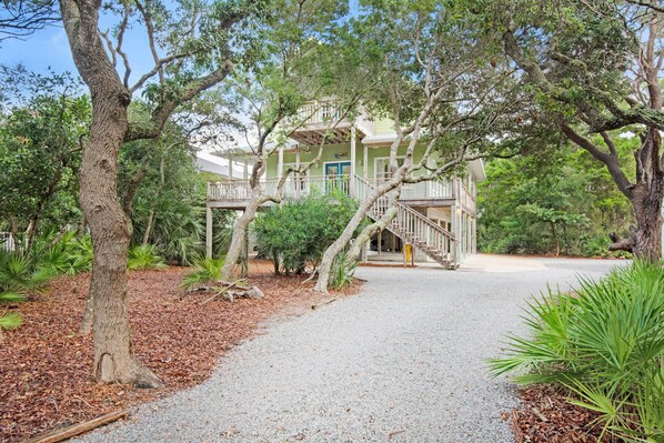A two-story building with a covered porch and a staircase leading to the upper level.