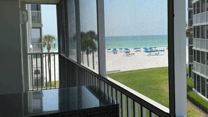 A balcony with a view of a beach and a building. - Beach & Pool Open! Beachfront View Every Room (Siesta Key)