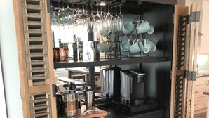 Una cocina con encimera negra, armarios de madera y una cafetera.