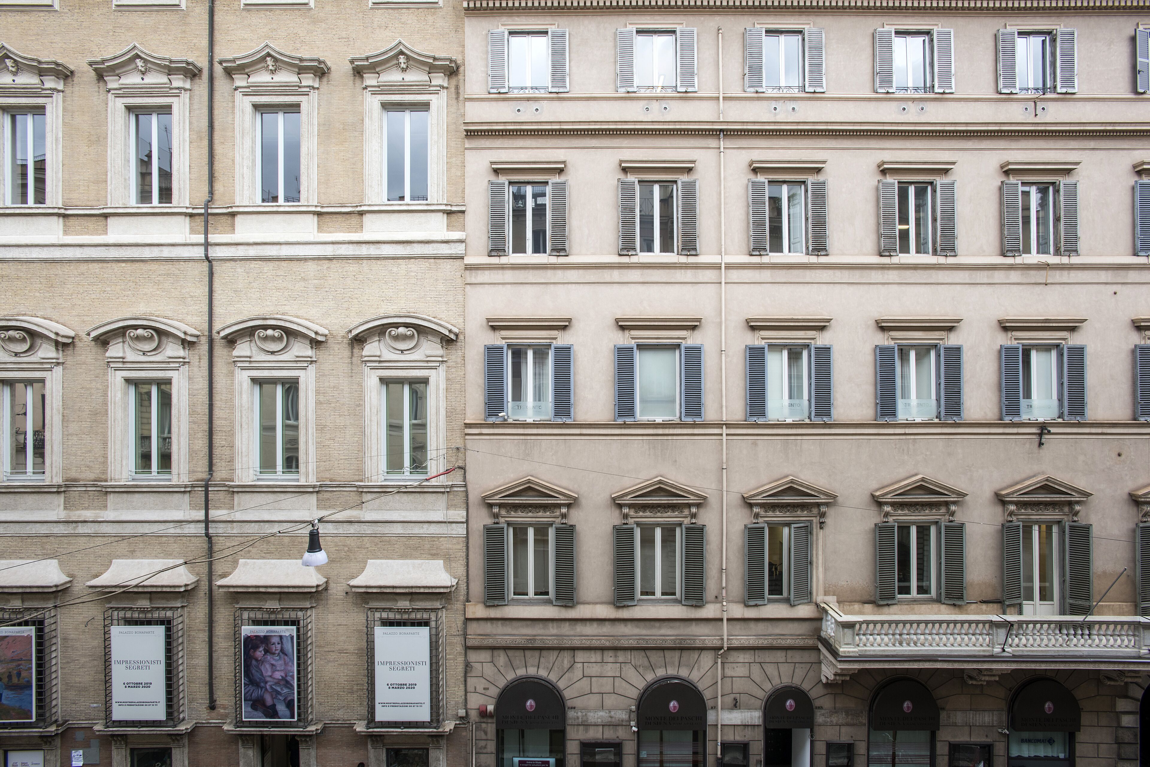 Une rangée d’immeubles à étages, tous de style architectural uniforme, caractérisés par des fenêtres en arc et des balcons.