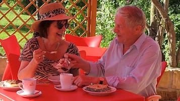 Two people seated at a table with a lattice structure in the background.