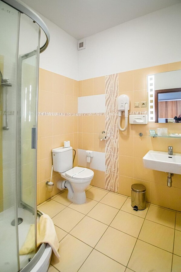 A bathroom with a glass shower enclosure, a toilet, a sink, and a zebra-patterned wall. - Hotel Academic (Zvolen)