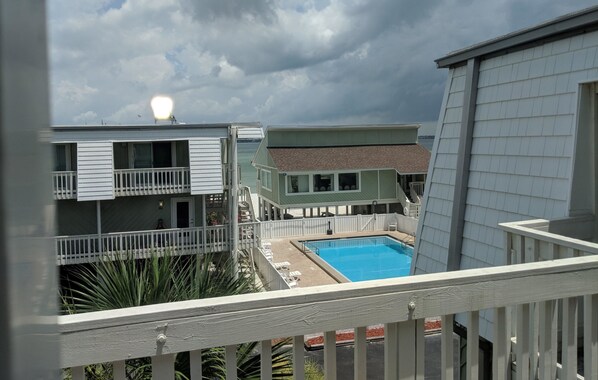 A view of a swimming pool area with a building in the background.