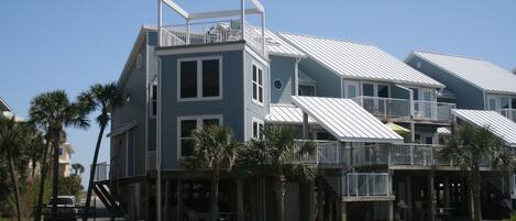 A multi-story building with balconies and a covered outdoor area.