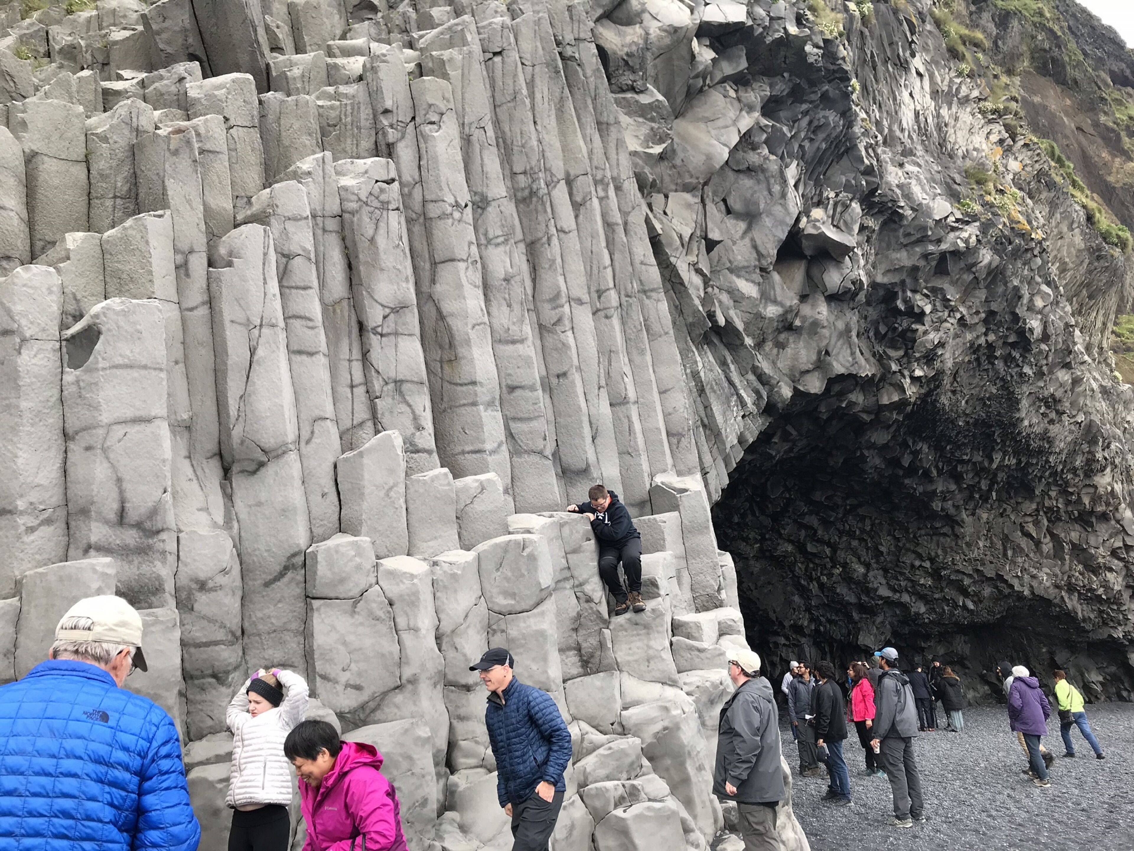 A rocky cliff with a cave entrance.