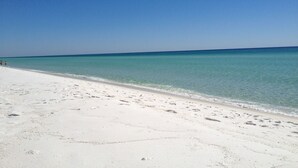Ein Strand mit klarem türkisblauem Wasser und weißem Sand.