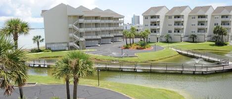 A hotel with multiple floors, a central courtyard with a water feature, and palm trees.