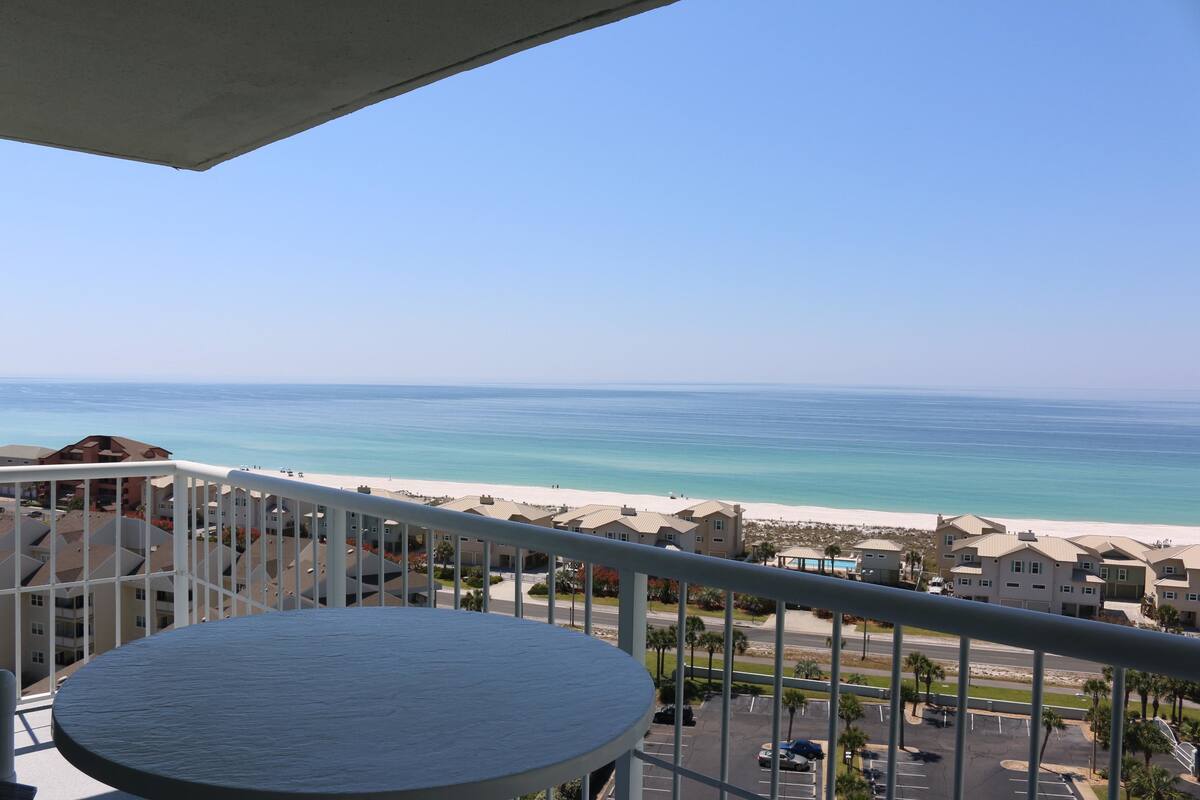 A balcony with a view of a beach and ocean.