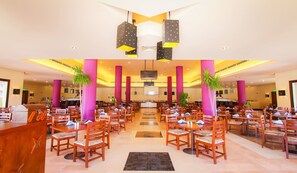 A spacious hotel lobby with multiple dining areas, large pillars, and hanging pendant lights. - Lemon And Soul Makadi Garden (Makadi Bay)